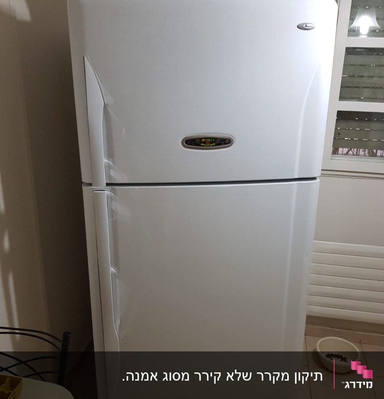 מקרר לבן עם ידיות ומדבקות על הדלת